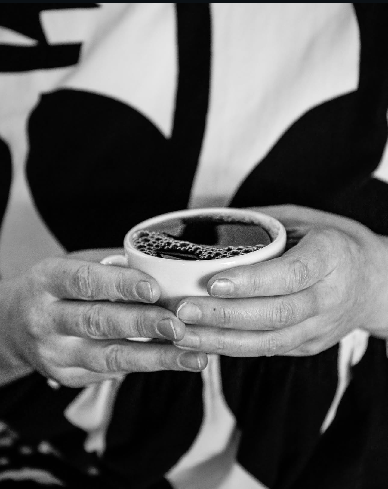 Person holding a cup of coffee with a blurred background