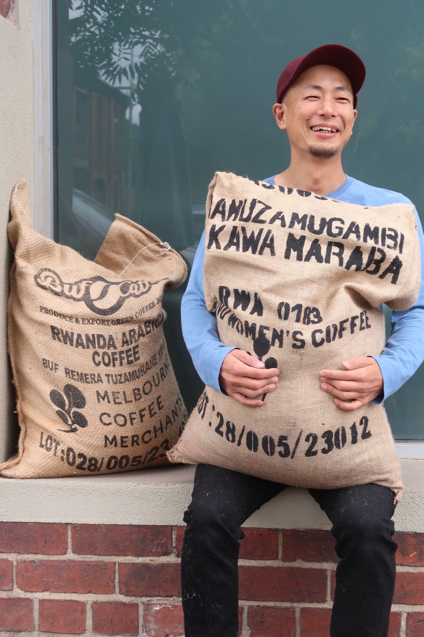 Person wearing multiple burlap coffee bags with visible text and branding.